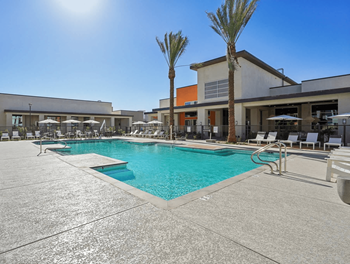 A large swimming pool with a sunny sky in the background.